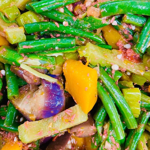 Close-up of Filipino Pinakbet with green beans, eggplant, bitter melon, and squash.