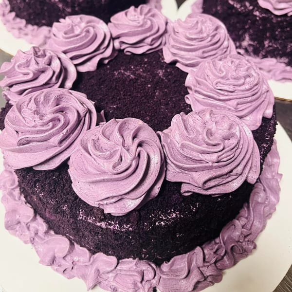 A Filipino ube cake with dark purple cake and light purple frosting swirls.