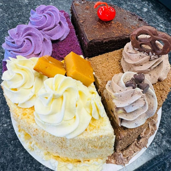 A round platter of Filipino cake slices, including ube, chocolate, and leche flan flavors.