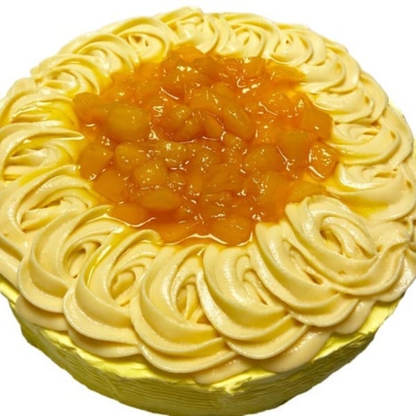 A Filipino mango cake with yellow frosting swirls and a center of diced mangoes.