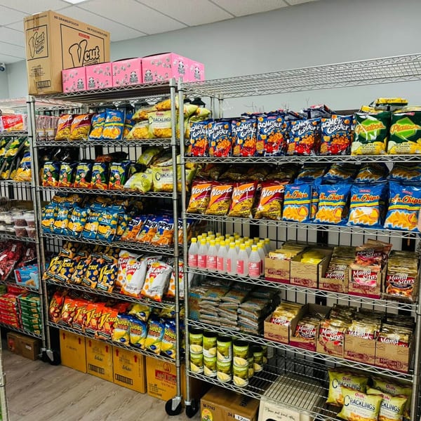 Shelves filled with various Filipino snacks, chips, and bottled drinks at a market.